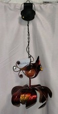 solar-powered hanging metal kinetic wind spinner featuring a red cardinal...