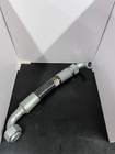 Gray 31.8X Buhler versatile hose Assy with coiled end fitting, resting on a black surface between white box sides.