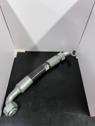 Gray 31.8X Buhler versatile hose Assy with coiled end fitting, resting on a black surface between white box sides.
