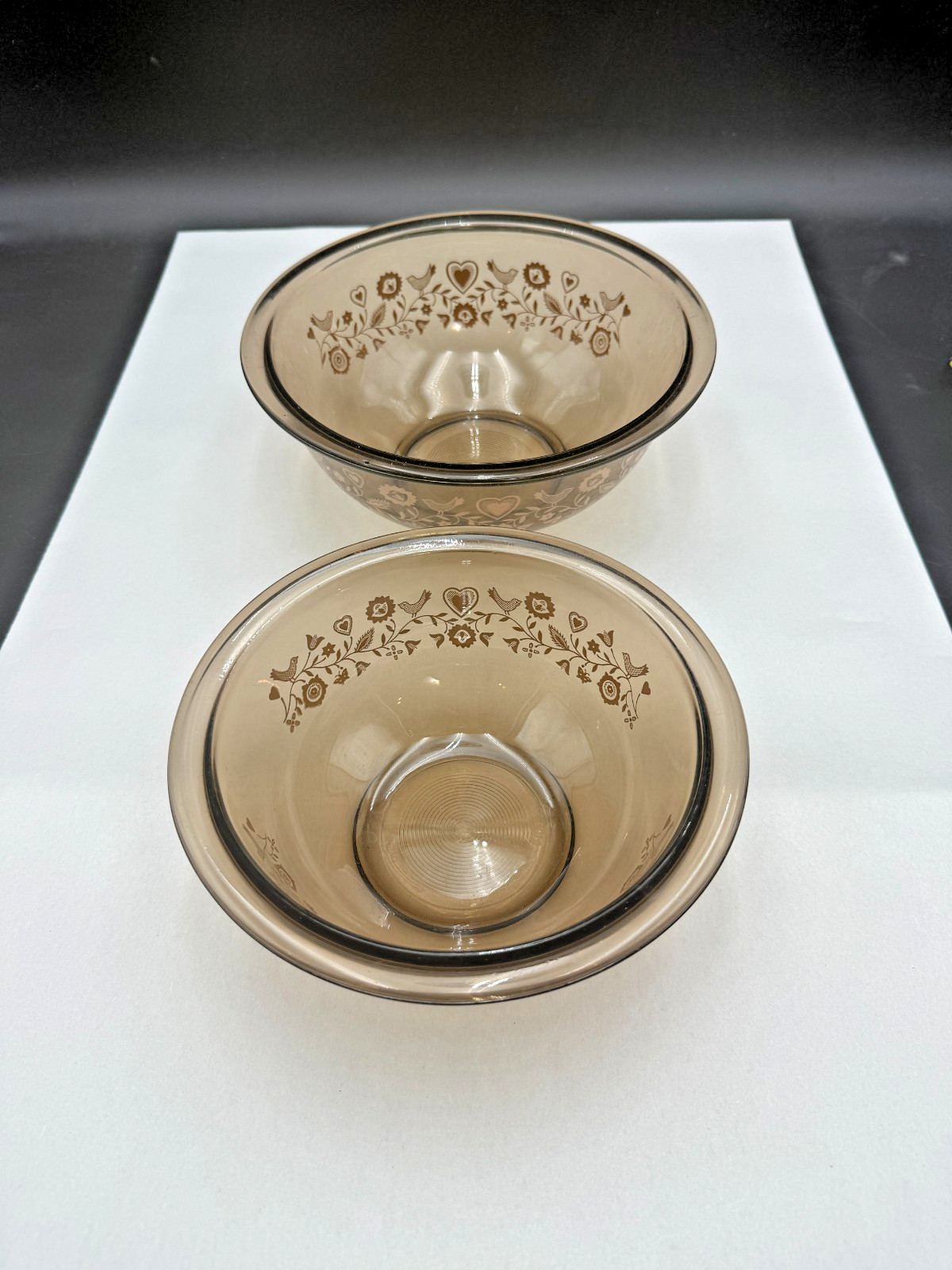 Two amber brown Pyrex nesting mixing bowls with the Festive Harvest pattern