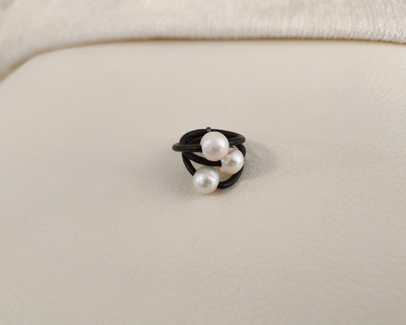 Anillo de cuero negro con tres perlas
