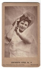 An 1890s CDV of a burlesque performer posing arms and face through torn paper — a genuinely rare, striking piece of Victorian performance photography.