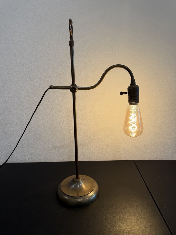 A 1910–1930 fully adjustable rise-and-fall brass desk lamp — 100-year-old articulating engineering that still looks futuristic.