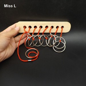 wooden puzzle with metal ring and rope