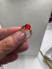 handmade gold-plated wire-wrapped ring with a red crystal and two gold-plated