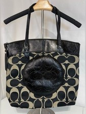 Coach Signature Laura tote bag with a distinct circular patent leather accent.