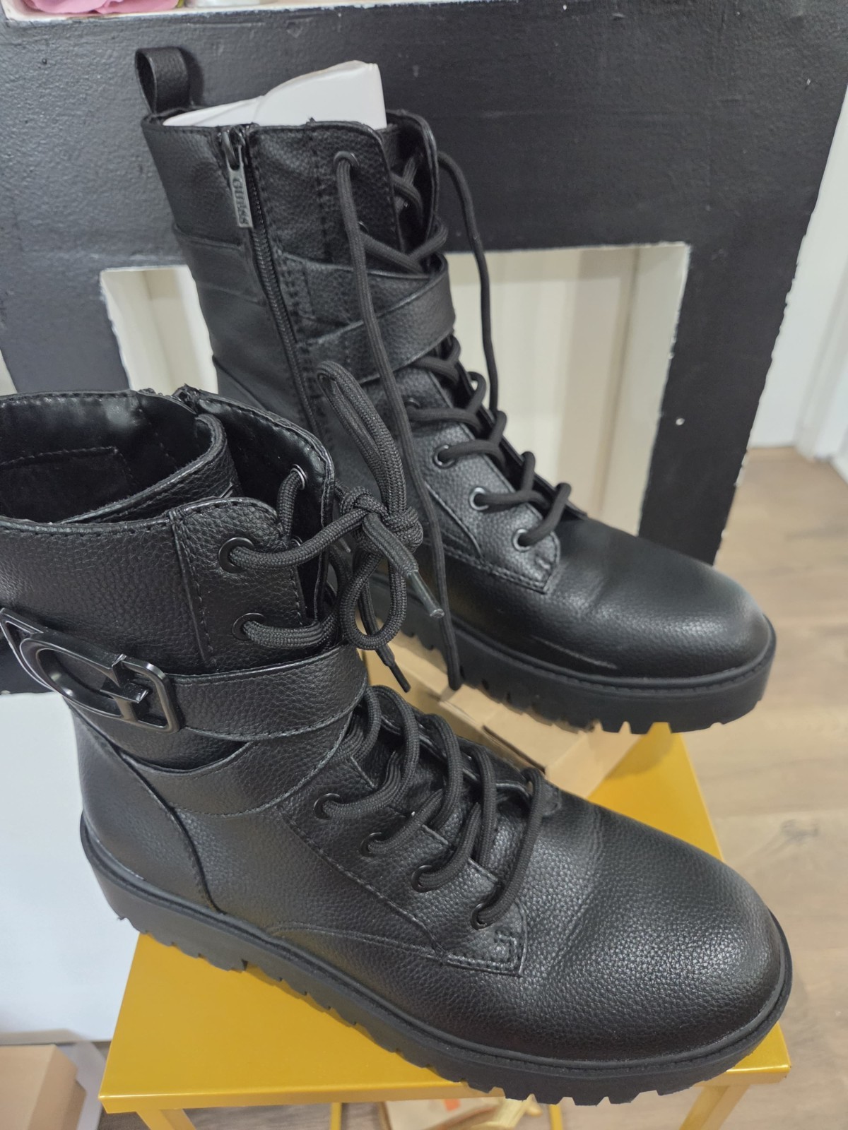 black GUESS Orana combat boots featuring a side zipper and a logo-embellished...