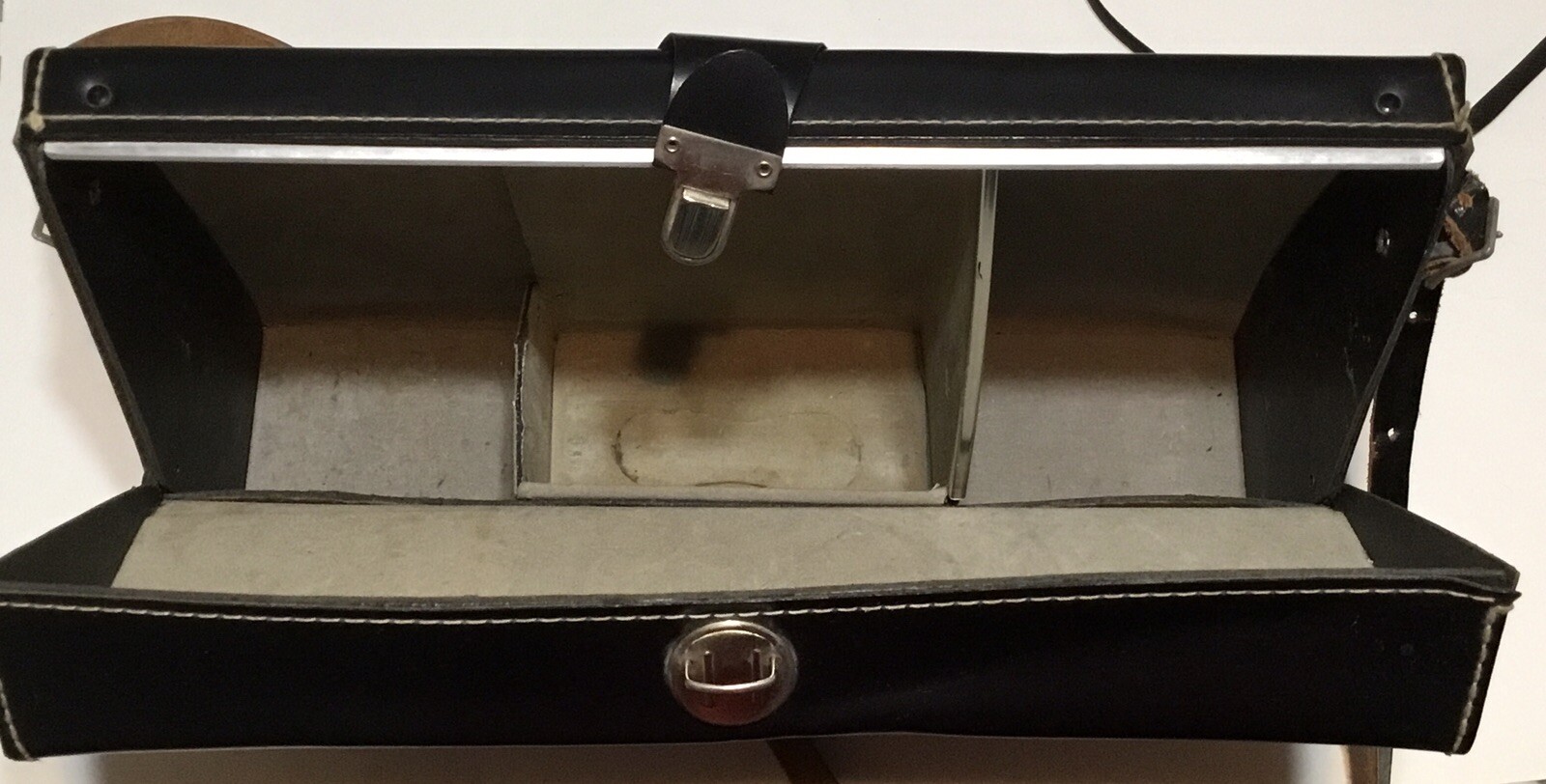 Black vintage hard camera case with two front pockets, stitched edges, and “Made in U.S.A.” text on top.