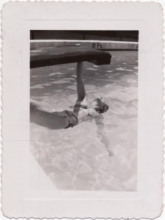 Woman hanging off diving board, 1940s