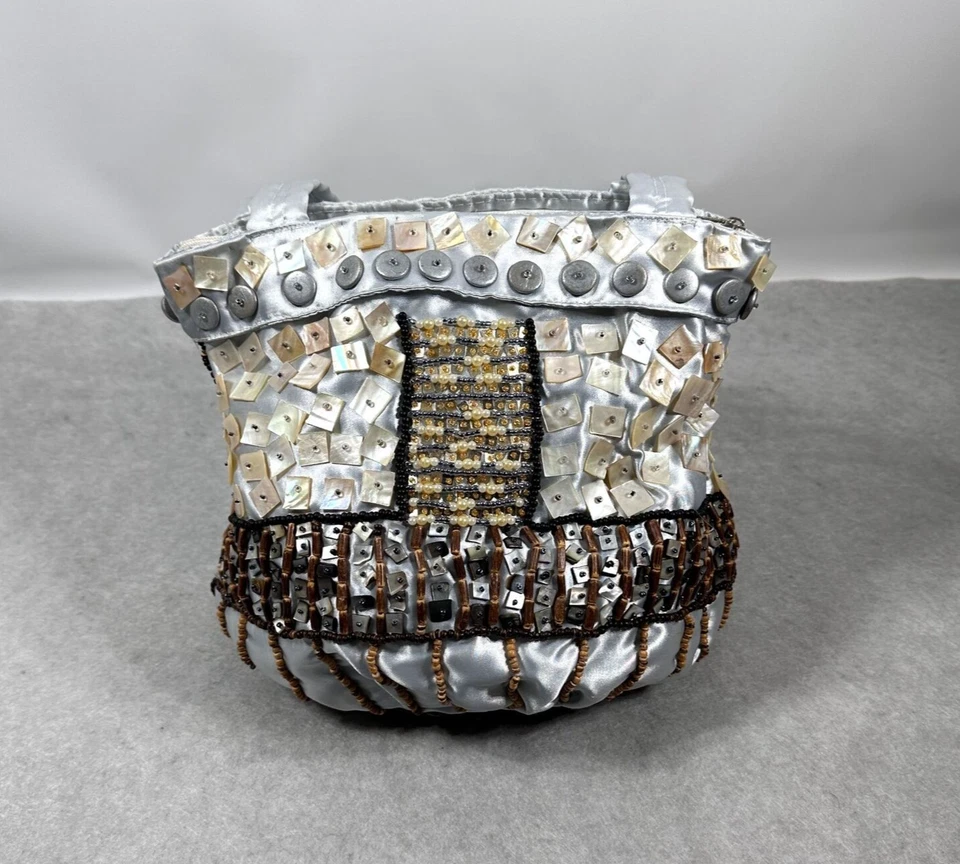 Cartera artesanal de satén plateada con adornos de botones y cuentas Foto 4 de 4