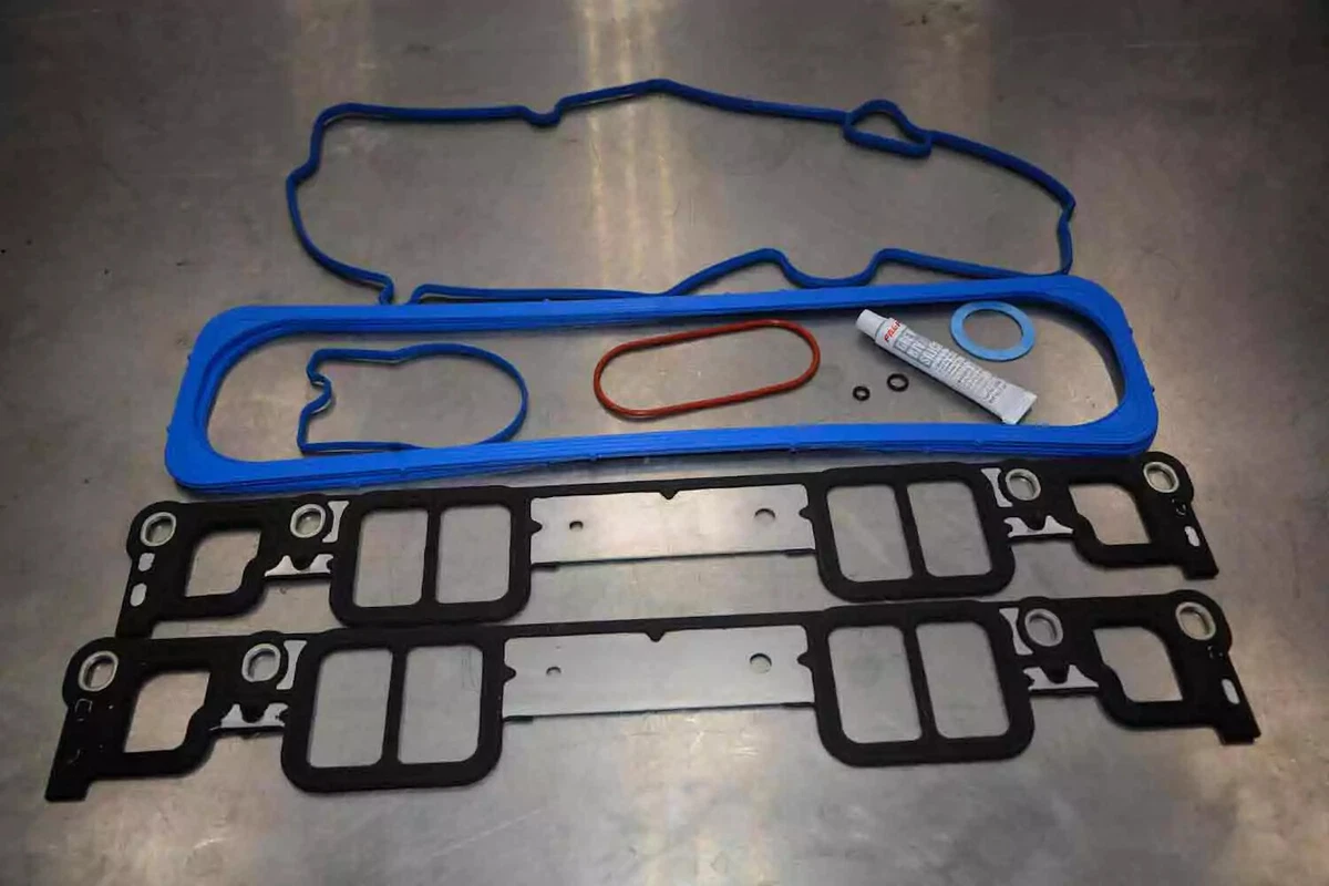 An intake manifold gasket kit for a 1999 Chevrolet Small Block 350 engine, displayed on a metal work surface.