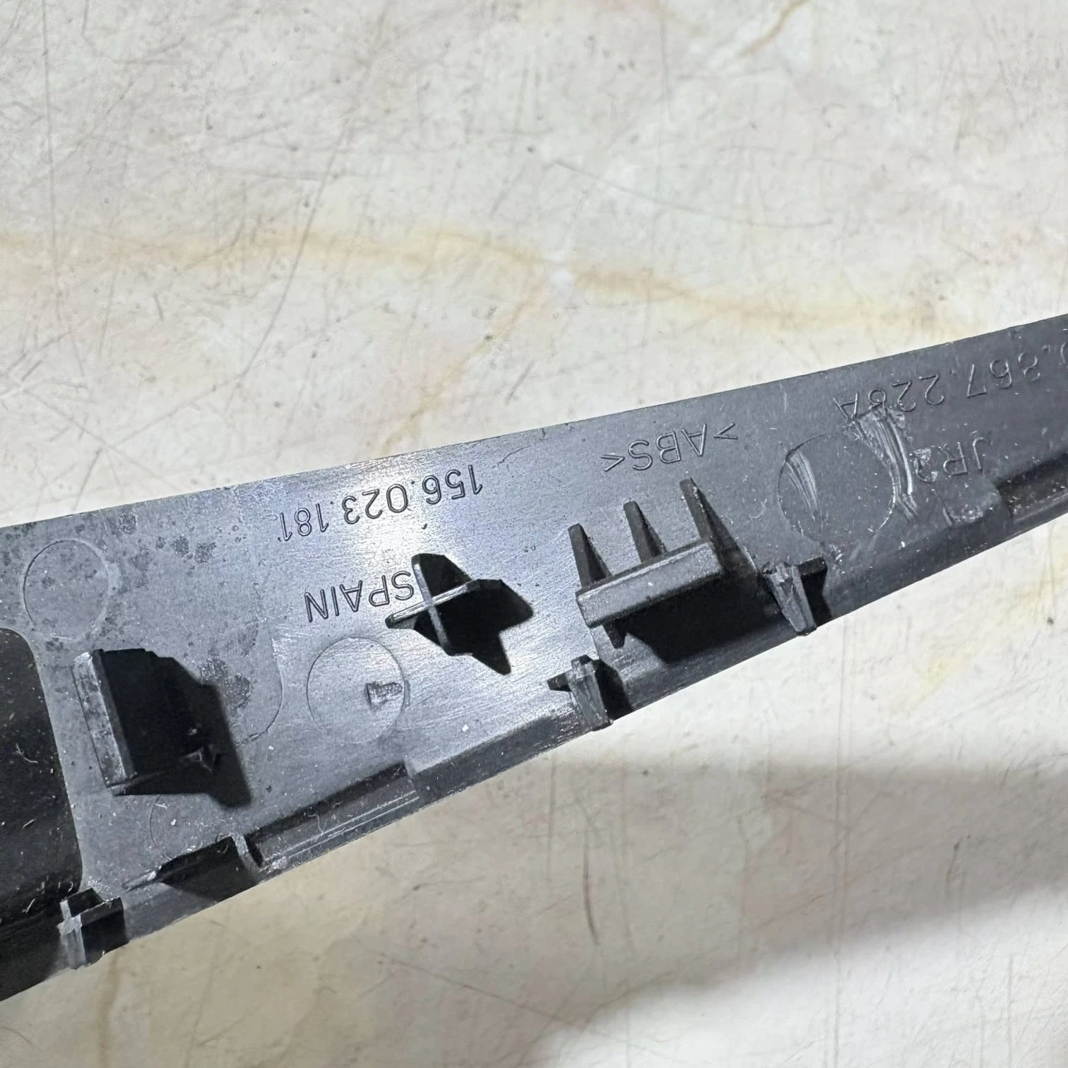 Close up of 1P0867228A and 156.023.181 moulded part numbers