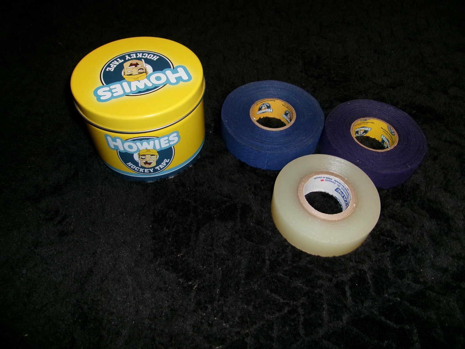 Howies Hockey Tape Tin w/ 3 clear rolls, 3/4 clear, 3/4 purple, full blue roll.