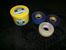 Howies Hockey Tape Tin w/ 3 clear rolls, 3/4 clear, 3/4 purple, full blue roll.