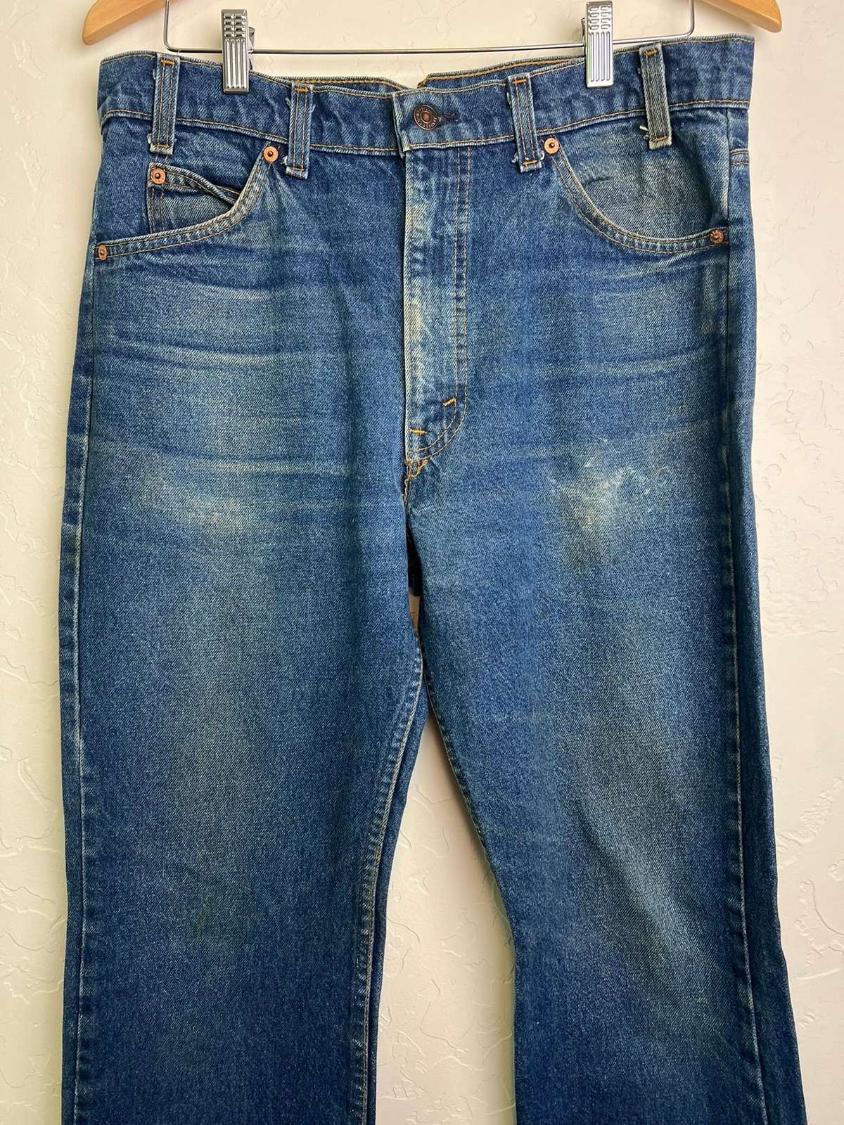 Blue Levi’s 517 vintage bootcut jeans with orange tab on waistband, front pockets, and visible yellow stitching.