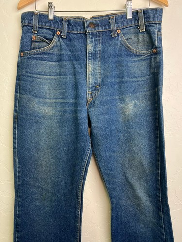 Blue Levi’s 517 vintage bootcut jeans with orange tab on waistband, front pockets, and visible yellow stitching.