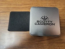 Scotty Cameron Tin with foam cutout for tees, divot tool, and ball marker.