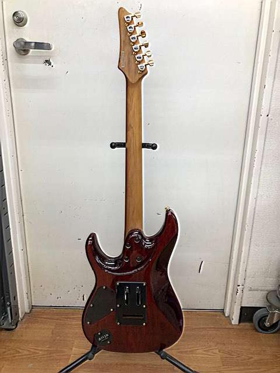 Ibanez AZ47P2K Dragoneyeburst used electric guitar with mahogany back, six strings, and gold hardware on stand.