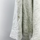 Close-up of a worn white baseball T-shirt with a small gold pinhole mark on the left sleeve, USA Made.
