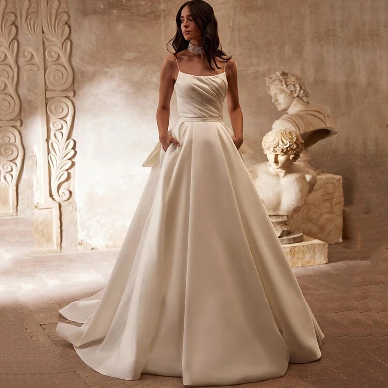 Spaghetti Straps Satin Wedding Dresses Backless Bow Pleated Pockets Bridal  Gowns