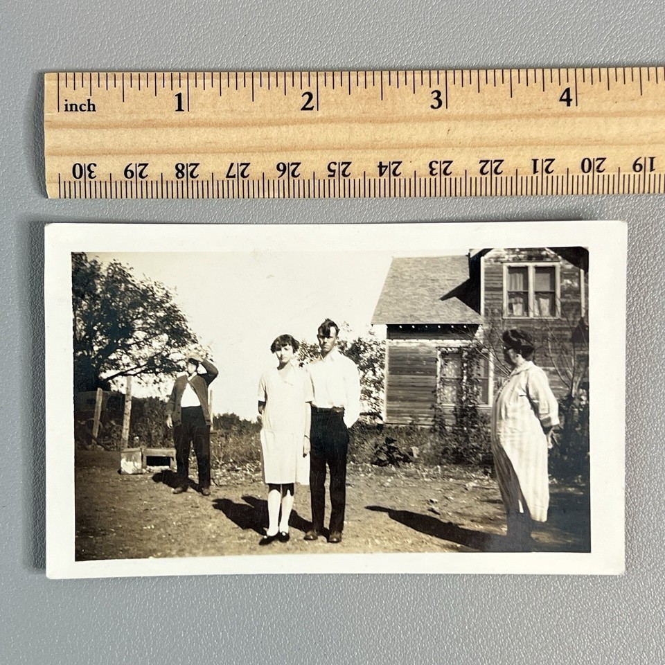 A genuine 1920s snapshot photo with hilariously awkward family staging and wild hair — the kind of weird one-of-a-kind artifact that becomes a conversation piece or ironic wall art instantly.