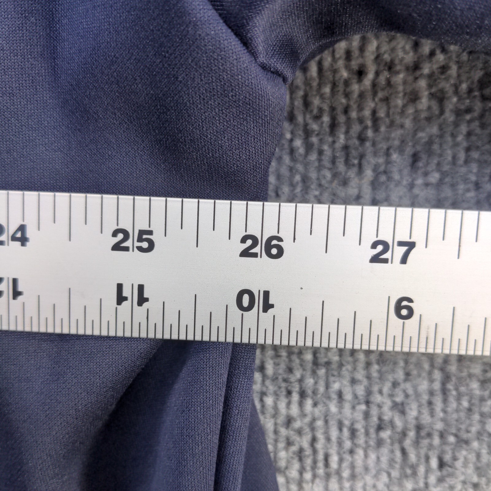 Blue full zip jacket with white stitching, 2XL size, shown against a gray tape measure on a light wood surface.
