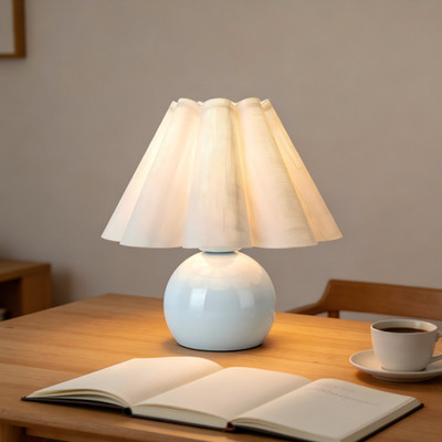 Table lamp with beige shade ideal for warm dining tables and morning coffee.