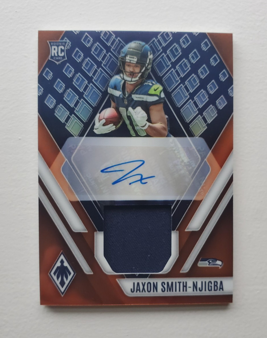 Jaxon Smith-Njigba #RAJ-JSN Football Cards 2023 Panini Phoenix RPS Rookie Autographs Jersey trading card — raw and PSA graded price guide
