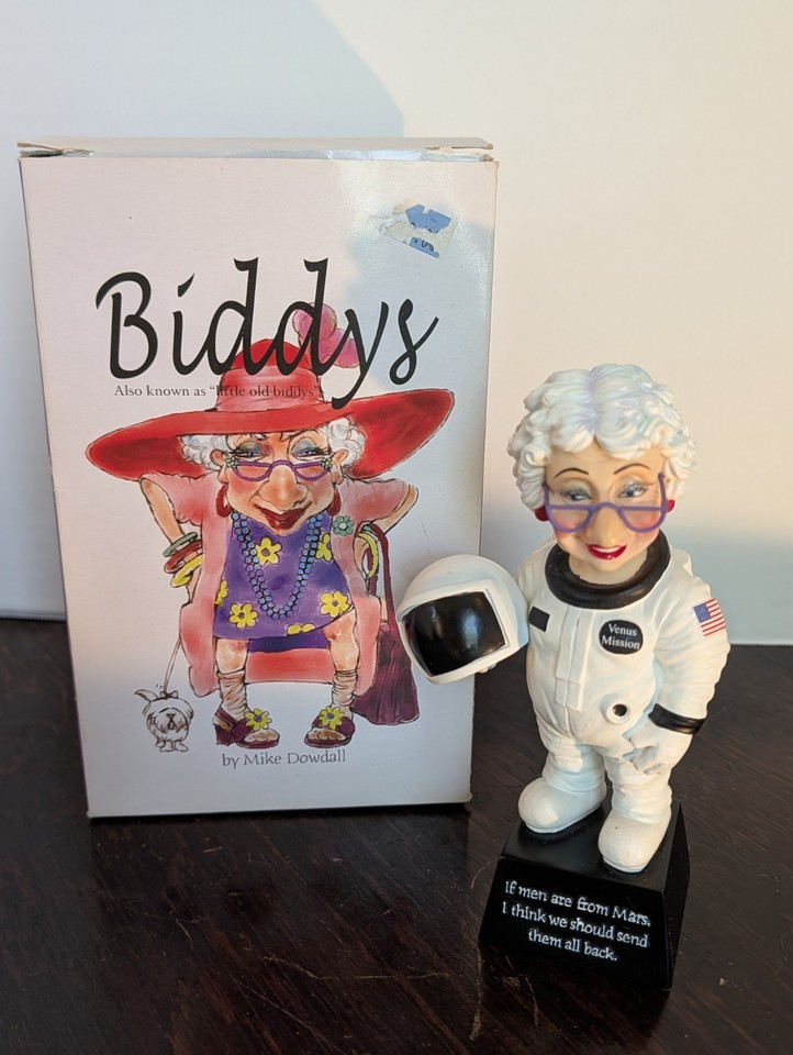 A tiny astronaut figurine from the Biddys series by Mike Dowdall — a legitimately collectible piece of early-2000s kitsch nostalgia that straddles retro-cute and space-age cool.