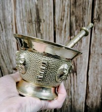 Mortier ancien en laiton/bronze avec pilon, décor de visages en relief