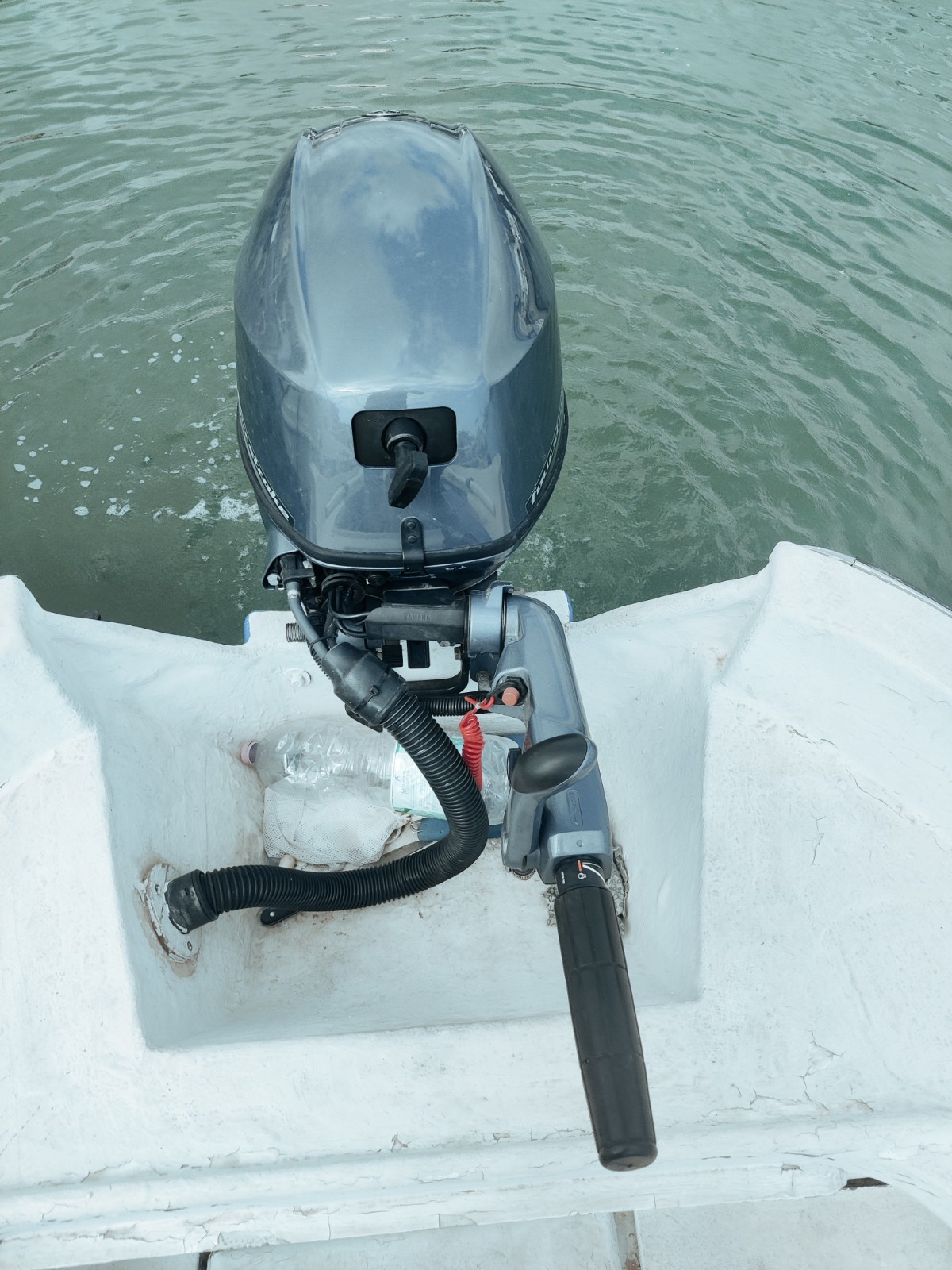 Barca a motore con tendalino e fuoribordo, canne da pesca e mulinelli