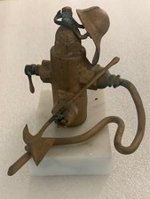 departamento de bomberos de latón vintage. trofeo; boca de riego, casco, hacha, manguera contra incendios sobre base de mármol