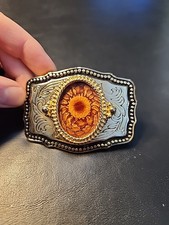 Gold-tone oval western belt buckle. Gold-tone inner rim. With sunflower design.