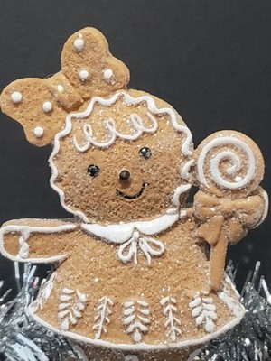 Gingerbread Girl with a Bow In Her Hair, Holding a Lollipop, Dusted In Glitter 
