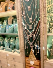 Silver necklace with pyramid-style design and a pearl stone