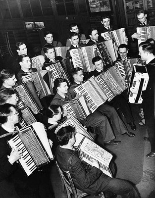 Night school students learn to play the accordion from their instr- Old Photo