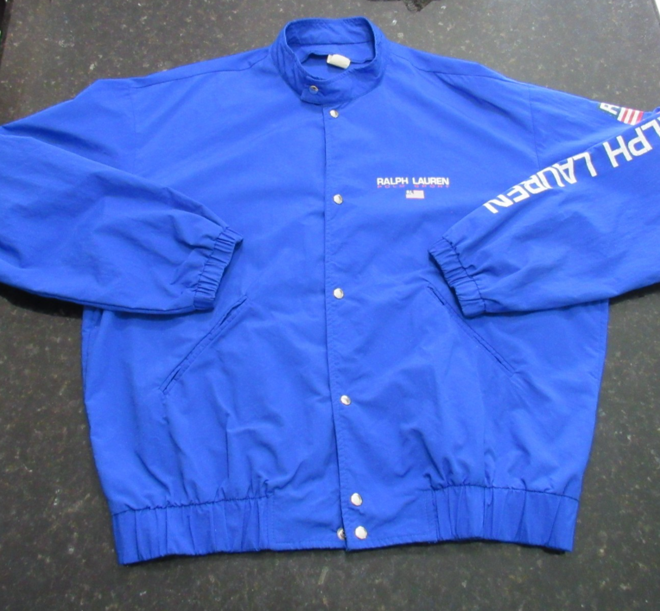 Blue Vtg 90s Polo Sport Ralph Lauren jacket with white “RL” logo and USA Made label on inner collar.