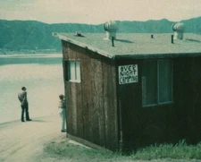 1970s Couple Lakeside Rustic Cabin Overnight Camping Sign Mountains Water