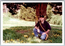 Vtg Color Snapshot Man Crouching By Tree With Caution Tape Yellow Flowers 1997