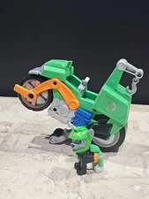 Paw Patrol Moto Pups Rocky’s Deluxe Pull Back Motorcycle Vehicle with Wheelie