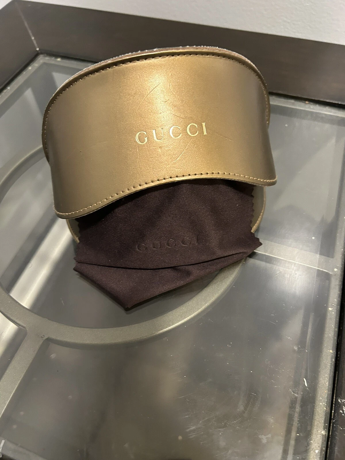Étui à lunettes de soleil Gucci uniquement. Couleur bronze surdimensionné avec lettrage doré