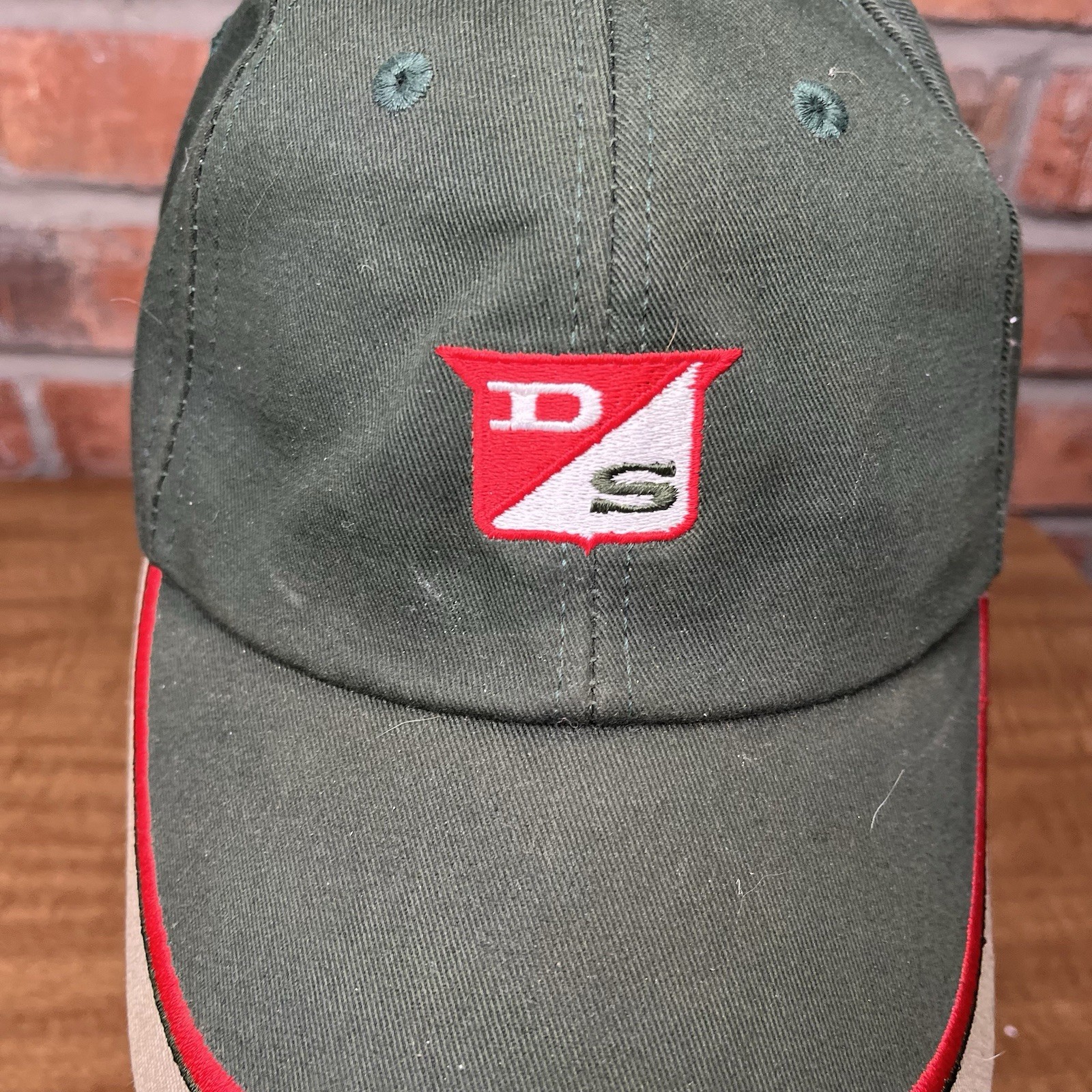 Green vintage baseball cap with red and white Dairyland Seed logo and embroidered “DS” on the front panel.