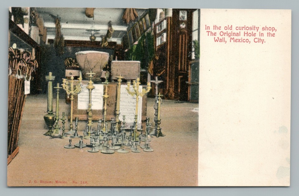 A genuinely rare early 1900s real-photo undivided back postcard capturing the atmospheric interior of a Mexico City curiosity shop — candlesticks, clutter, and all the mysterious charm of an old cabinet of wonders.