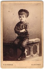 Fotografie A. E. Diener, Glauchau, am Theaterlocal, sehr junger Knabe mit ernst 