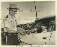 1975 Press Photo Lieutenant Walter LeBlanc presents bumper sticker to motorist