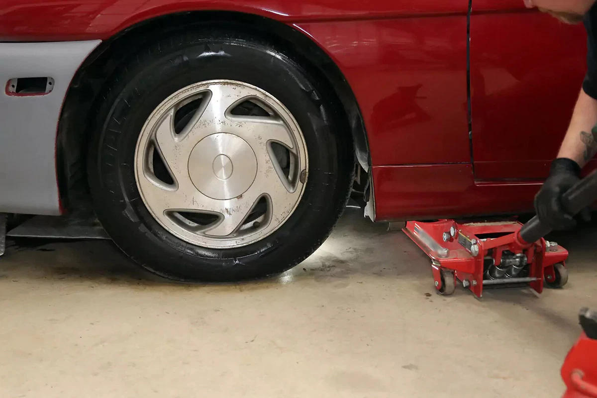 Lifting the vehicle with a floor jack.