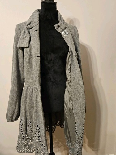 Gray wool blend women’s short coat with high collar, front button closure, and floral edge detailing on sleeves and seams.