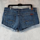 Blue stretch denim shorts with back pocket, tan leather patch, and light blue cuffed hems, size 32.