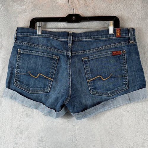 Blue stretch denim shorts with back pocket, tan leather patch, and light blue cuffed hems, size 32.