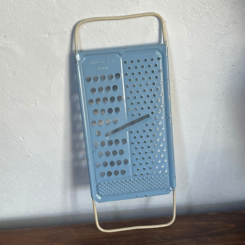 An all-in-one vintage blue-handled cheese grater/slicer from Taiwan with serious retro diner energy — the pop of cobalt color alone makes it a countertop conversation piece.